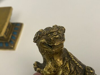 A pair of Chinese gilt copper alloy Buddhist lions on champlev&eacute; enamel bases, 19th C.