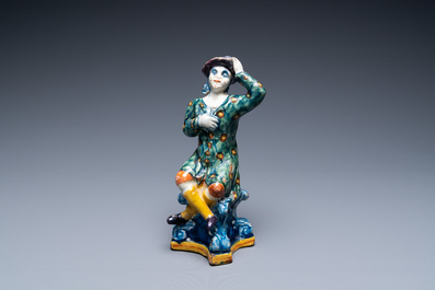 A polychrome Dutch Delft figure of a seated man and a blue and white one of a seated lady, 18th C.
