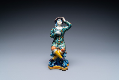A polychrome Dutch Delft figure of a seated man and a blue and white one of a seated lady, 18th C.