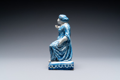 A polychrome Dutch Delft figure of a seated man and a blue and white one of a seated lady, 18th C.