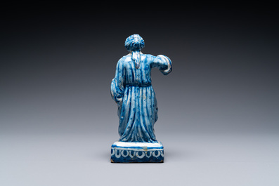 A polychrome Dutch Delft figure of a seated man and a blue and white one of a seated lady, 18th C.