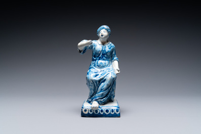 A polychrome Dutch Delft figure of a seated man and a blue and white one of a seated lady, 18th C.