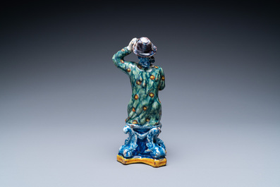 A polychrome Dutch Delft figure of a seated man and a blue and white one of a seated lady, 18th C.
