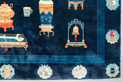 Een groot Chinees tapijt met decor van antiquiteiten op blauwe fondkleur, 19e eeuw