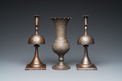 A pair of Qajar damascened candlesticks and a vase, Persia, 19th C.
