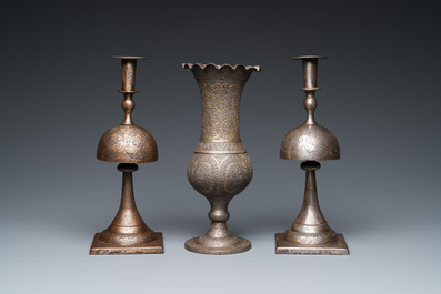 A pair of Qajar damascened candlesticks and a vase, Persia, 19th C.