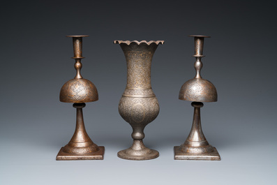 A pair of Qajar damascened candlesticks and a vase, Persia, 19th C.