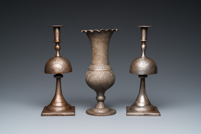 A pair of Qajar damascened candlesticks and a vase, Persia, 19th C.