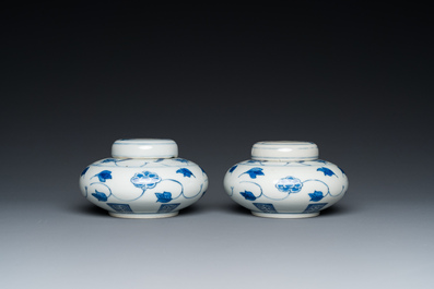 A pair of small Chinese blue and white covered vases on wooden stands, Xuande mark, 19/20th C.