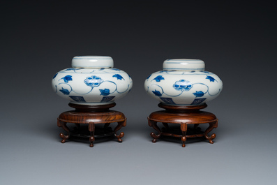 A pair of small Chinese blue and white covered vases on wooden stands, Xuande mark, 19/20th C.