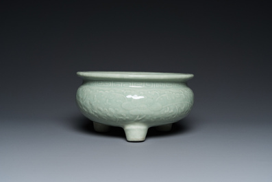 Een Chinese celadon-geglazuurde driepotige wierookbrander met florale slingers op houten voet, Qing