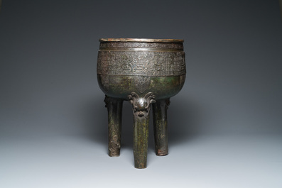 Een grote Chinese driepotige bronzen wierookbrander op houten voet en sokkel, Qing