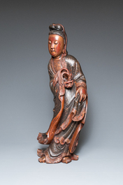 A large Chinese gilt-lacquered wood figure of Guanyin on a carved wooden stand, 17th C.