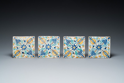 Four rare polychrome small size Dutch Delft tiles with grapes and pomegranates, 1st half 17th C.