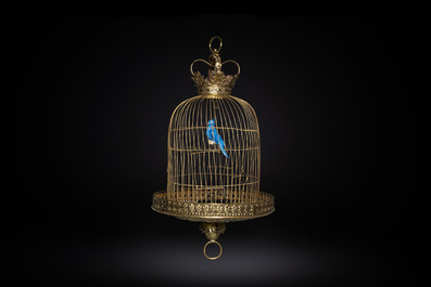 A Dutch or Flemish yellow brass bird cage with a porcelain bird, 18th and 19th C.