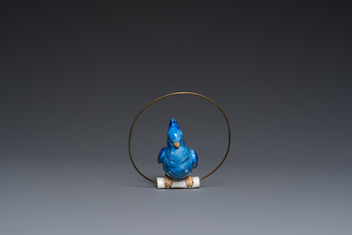 A Dutch or Flemish yellow brass bird cage with a porcelain bird, 18th and 19th C.