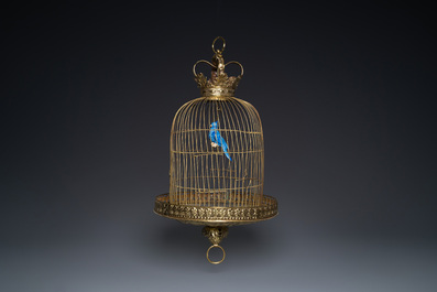 A Dutch or Flemish yellow brass bird cage with a porcelain bird, 18th and 19th C.