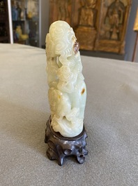 A Chinese celadon and russet jade ram sculpture on wooden stand, 19th C.