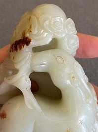 A Chinese celadon and russet jade ram sculpture on wooden stand, 19th C.