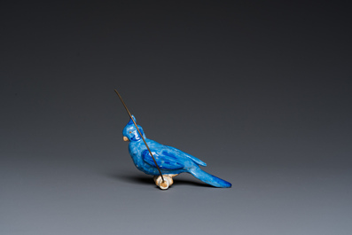 A Dutch or Flemish yellow brass bird cage with a porcelain bird, 18th and 19th C.