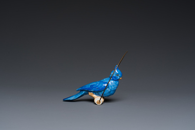 A Dutch or Flemish yellow brass bird cage with a porcelain bird, 18th and 19th C.