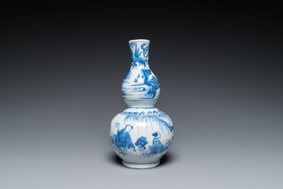 A Chinese blue and white double gourd vase with figures in a landscape, Transitional period