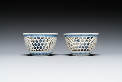 Een paar Chinese blauw-witte opengewerkte dubbelwandige koppen en schotels, Kangxi