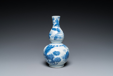 A Chinese blue and white double gourd vase with figures in a landscape, Transitional period