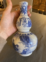 A Chinese blue and white double gourd vase with figures in a landscape, Transitional period