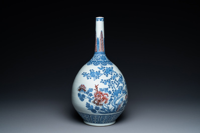 A Chinese blue, white and copper-red bottle vase with a deer and birds among blossoming branches, 19th C.