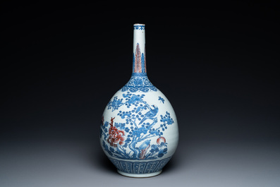 A Chinese blue, white and copper-red bottle vase with a deer and birds among blossoming branches, 19th C.