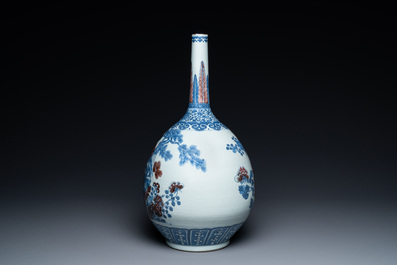 A Chinese blue, white and copper-red bottle vase with a deer and birds among blossoming branches, 19th C.