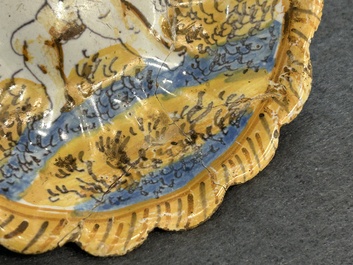 Een polychroom majolica schoteltje met een vechtende putto, atelier Verstraeten, Haarlem, 17e eeuw