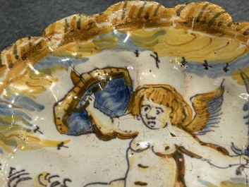 Een polychroom majolica schoteltje met een vechtende putto, atelier Verstraeten, Haarlem, 17e eeuw