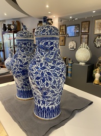 A pair of Chinese blue and white covered vases with floral sprigs, 19th C.
