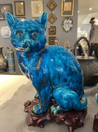 A Chinese turquoise-glazed cat and a dog on wooden stands, 19th C.