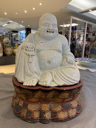 Een Chinese blanc de Chine Boeddha op gelakte en vergulde houten 'lotus' sokkel, Qianlong/Jiaqing