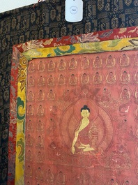 Thangka figurant Bouddha de M&eacute;decine ou Bhaishajyaguru entour&eacute; de Bouddhas Shakyamuni sur fond rouge, Tibet ou N&eacute;pal, 19/20&egrave;me