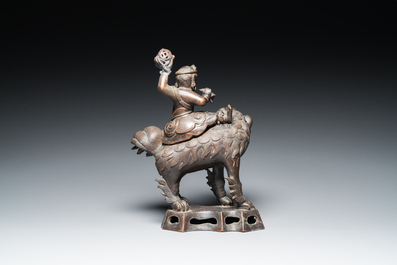 A Chinese bronze censer and cover in the shape of a Luohan on a Buddhist lion, late Ming/early Qing