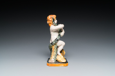A polychrome Brussels faience sculpture of a putto with a snake standing on a lion, late 18th C.