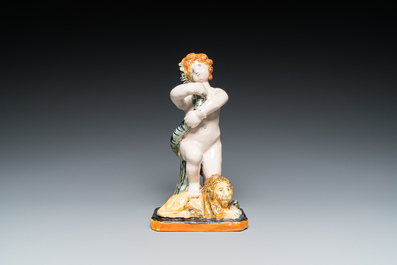 A polychrome Brussels faience sculpture of a putto with a snake standing on a lion, late 18th C.