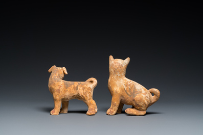Twee Chinese 'mingqi' beschilderde aardewerken modellen van honden, Han