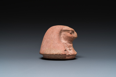An Egyptian light brown limestone canopic lid in the shape of a falcon head, Late Period
