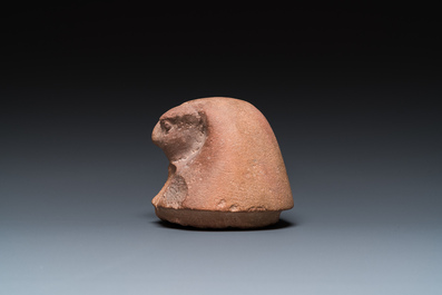 An Egyptian light brown limestone canopic lid in the shape of a falcon head, Late Period