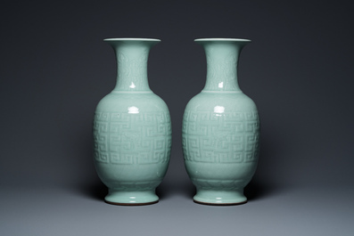 Een paar Chinese monochrome celadon vazen met onderglazuur decor op houten sokkels, Qianlong merk, 18/19e eeuw