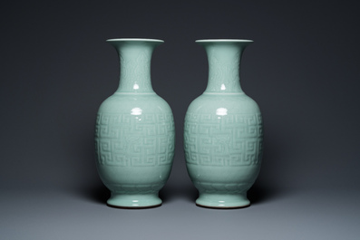 Een paar Chinese monochrome celadon vazen met onderglazuur decor op houten sokkels, Qianlong merk, 18/19e eeuw