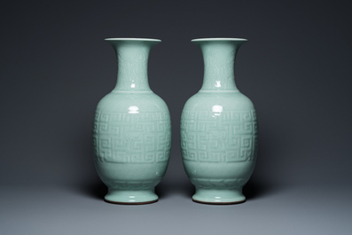 Een paar Chinese monochrome celadon vazen met onderglazuur decor op houten sokkels, Qianlong merk, 18/19e eeuw