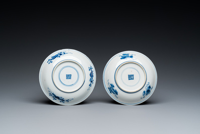 A pair of Chinese blue and white 'carps' cups and saucers, Kangxi