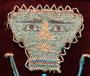 Un masque de momie en r&eacute;sille de perles en fa&iuml;ence, un oushebti et un collier, Egypte, p&eacute;riode ptol&eacute;ma&iuml;que