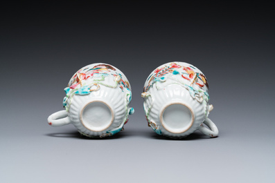 A pair of Chinese famille rose relief-decorated cups and saucers, Yongzheng